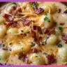 Bowl of creamy bacon cheddar gnocchi soup garnished with herbs