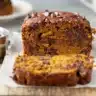 Slice of banana chocolate chip pumpkin bread garnished with nuts