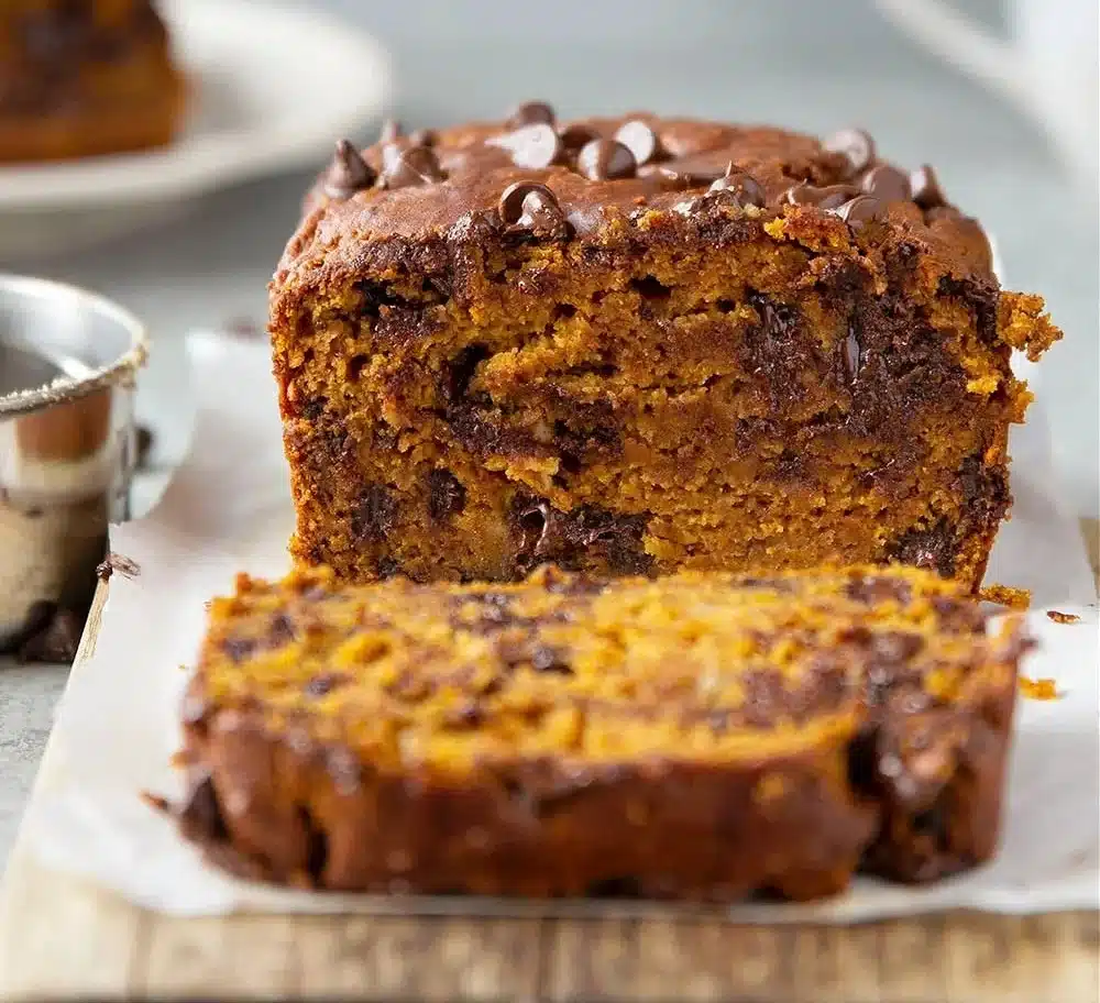 Slice of banana chocolate chip pumpkin bread garnished with nuts