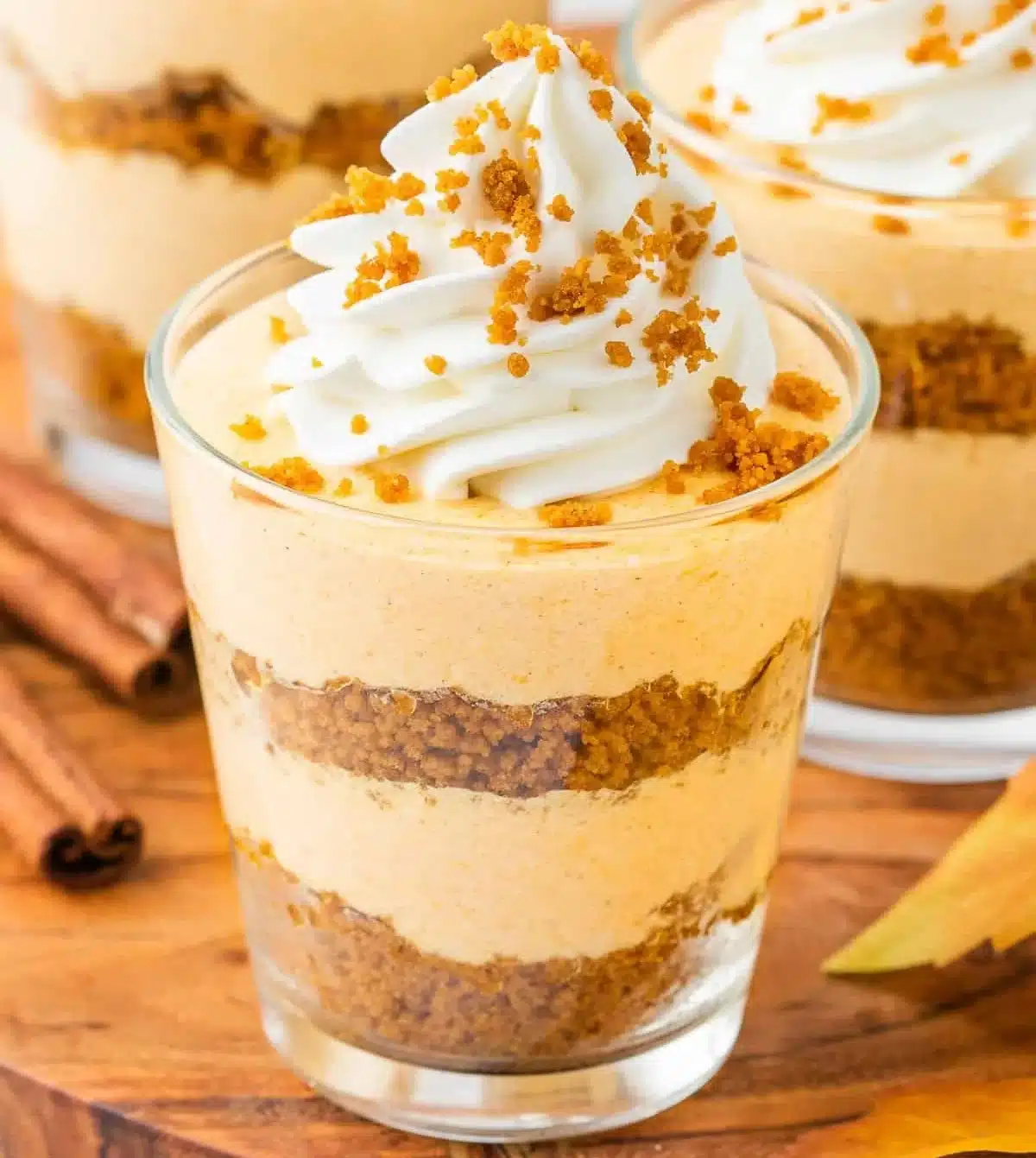 Delicious pumpkin pie in a cup topped with whipped cream and spices
