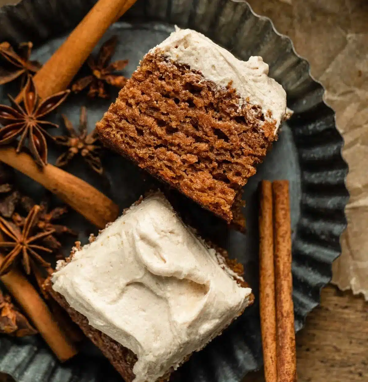 Slice of apple spice cake topped with buttercream frosting on a plate